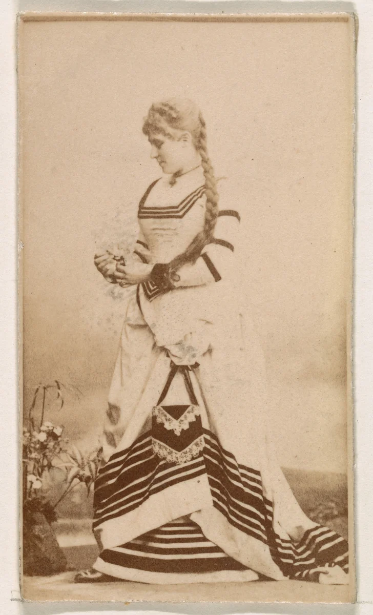 Standing actress in striped gown, from the Actresses series (N245) issued by Kinney Brothers to promote Sweet Caporal Cigarettes by Kinney Brothers Tobacco Company, photograph, 1890