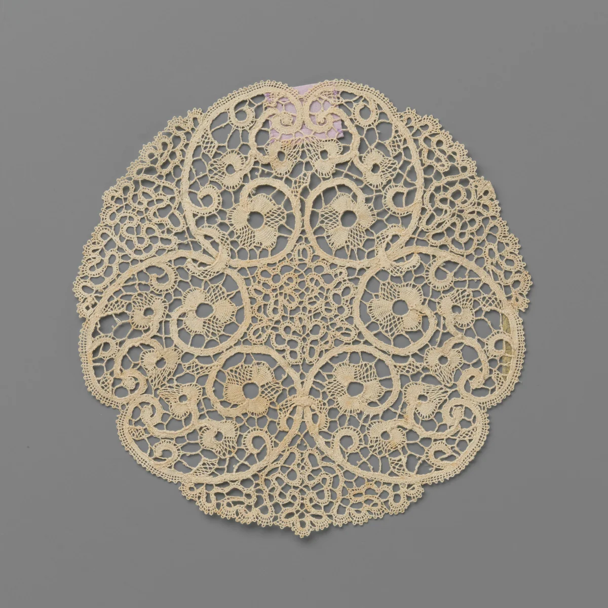 Rond vingerkomkleedje van kloskant met naar elkaar toegewende c-voluten en slingerende linten by anonymous, textile, 1900-1999