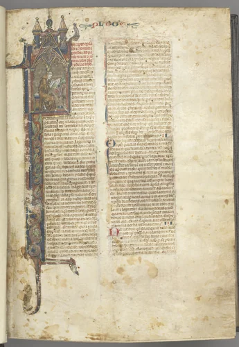 Fol. ir: Prologue, St. Jerome, large historiated initial I, the saint in a brown habit writing at a desk in a gothic architectural frame, with full-length border of foliage and small hybrids, a hare, a dog and a grotesque perched on the foliage extensions by Unknown, book, 1270-1300