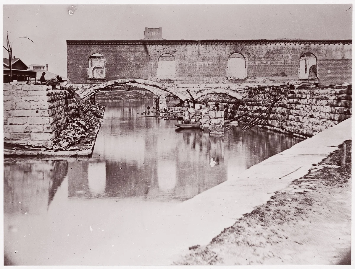 [Canal and Ruins of Richmond and Danville Railroad Depot, Richmond, Virginia] by Alexander Gardner, photograph, 1865