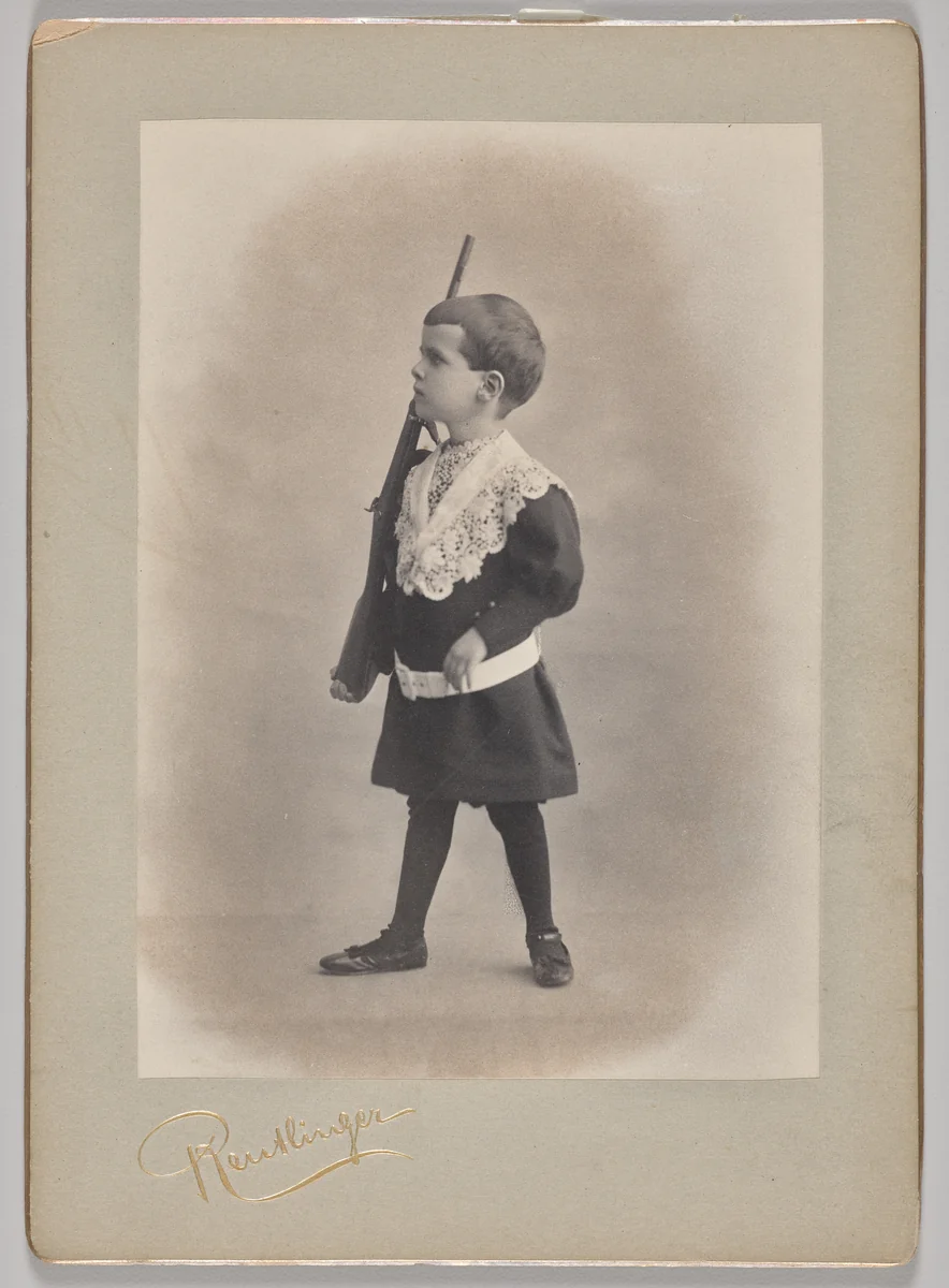 Untitled (young boy with lace collar and toy rifle) by Reutlinger Studios, photograph, 1880-1899