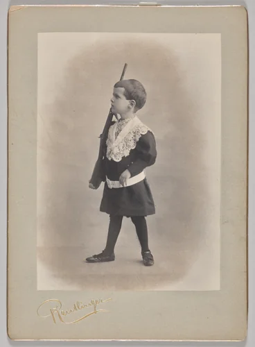 Untitled (young boy with lace collar and toy rifle) by Reutlinger Studios, photograph, 1880-1899