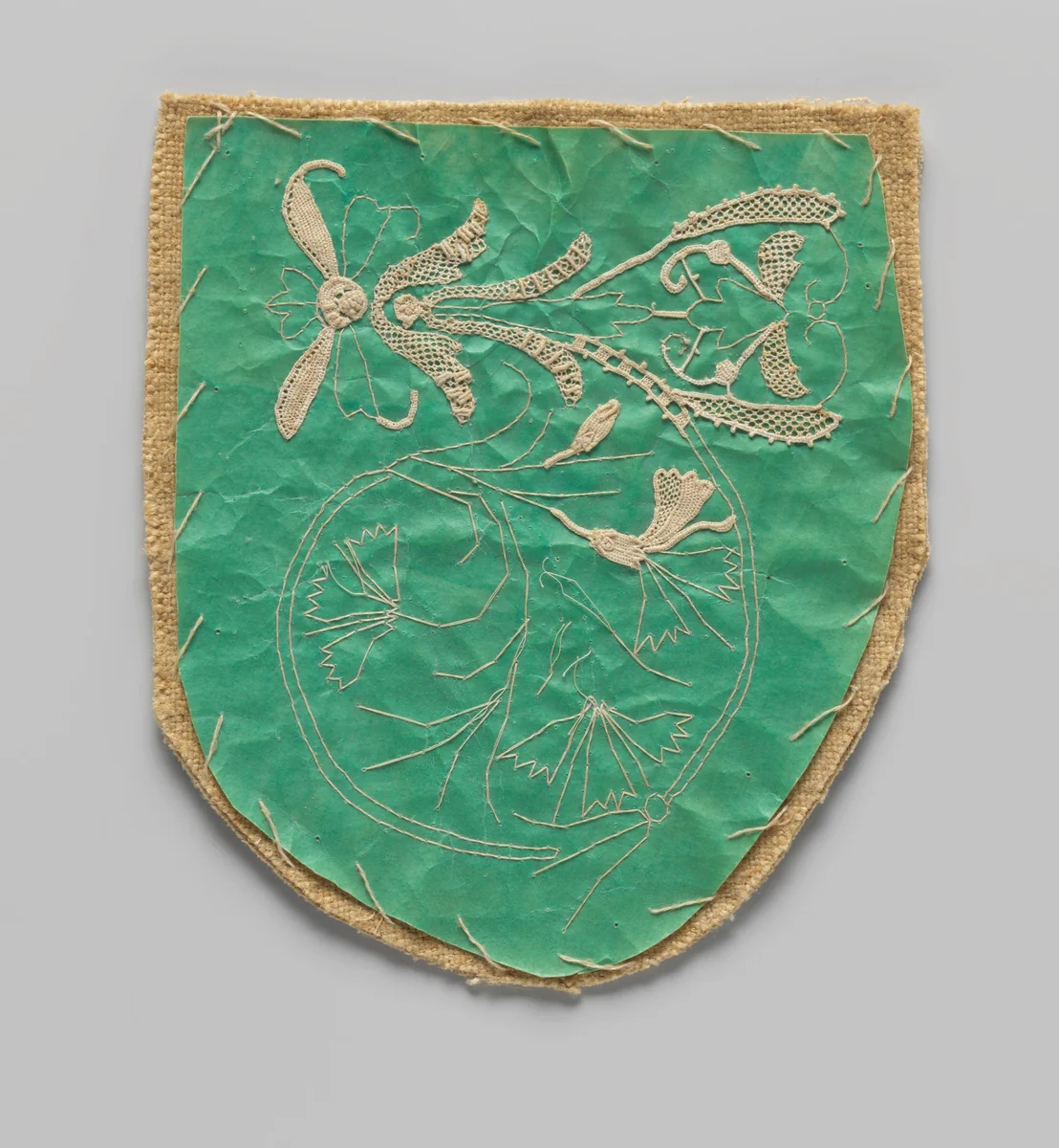 Werkstuk van naaldkant motieven in wording op groene prikking met linnen ondergrond by anonymous, textile, 1875-1899