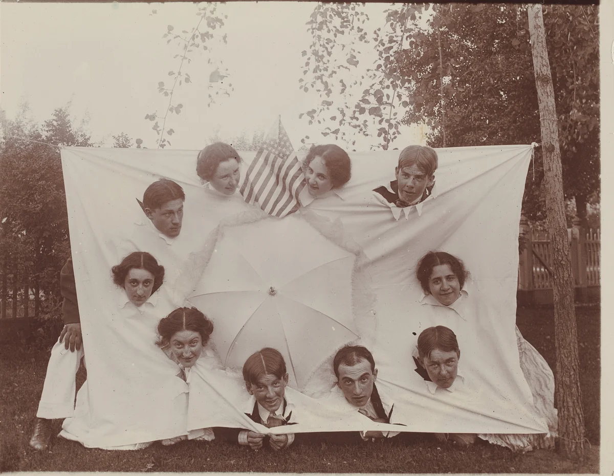 Untitled (Group sticking heads through a sheet) by American 20th Century, photograph, 1890-1919
