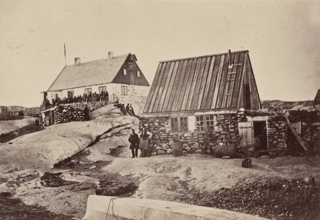 "Motzfeldt's House, in which the ball was given, with a group of Esquimaux in front of it. The house in the foreground is his private residence." by George P. Critcherson, John L. Dunmore, William Bradford, photograph, 1869