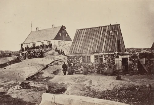 "Motzfeldt's House, in which the ball was given, with a group of Esquimaux in front of it. The house in the foreground is his private residence." by George P. Critcherson, John L. Dunmore, William Bradford, photograph, 1869