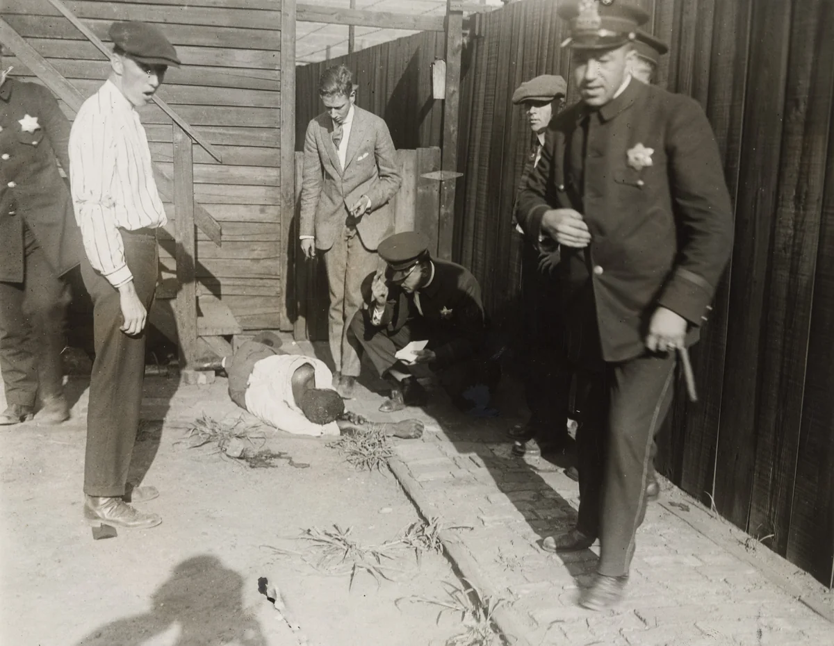 "Police Trying to Identify Colored Victim of the Mob" by International Film Service, photograph, 1919