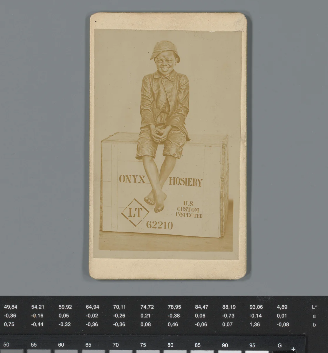 Reclame voor zwarte kousen van Onyx met reproductie van een racistische prent van zittende jongen op een kist by anonymous, photograph, 1850-1915