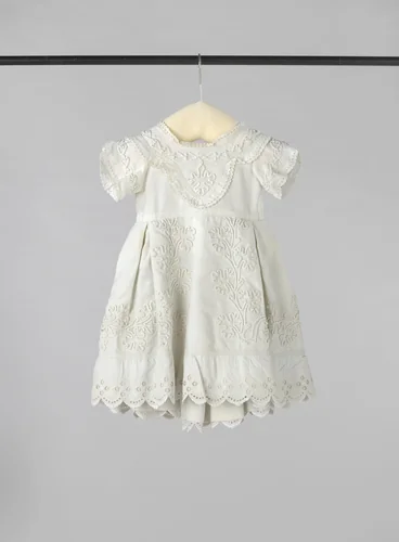 Kinderjurk van witte katoen met een ingeweven ribbel, versierd met soutache, Engels borduurwerk en passement. by anonymous, other, 1870-1880