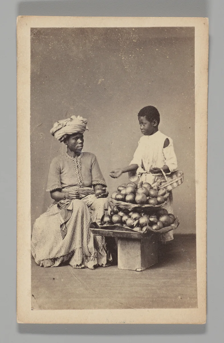 [Studio Portrait: Seated Woman and Standing Boy Street Vendors with Vegetable Baskets, Brazil] by Christiano Junior, photograph, 1864