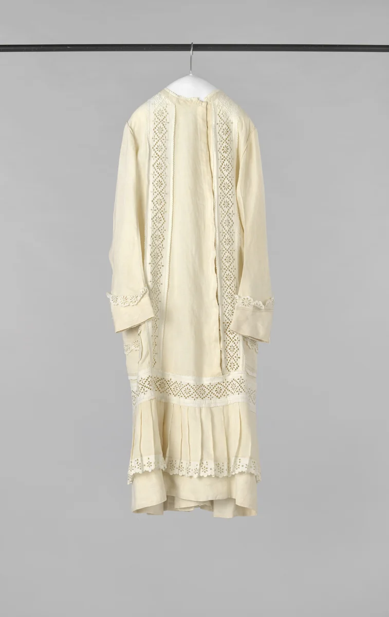 Kinderjurk met lange mouw, van achter recht, van voren met zeer lage taille, sluiting, geplooide rok en twee steekzakken, van écru linnen, versierd met Engels borduurwerk by anonymous, other, 1875-1880