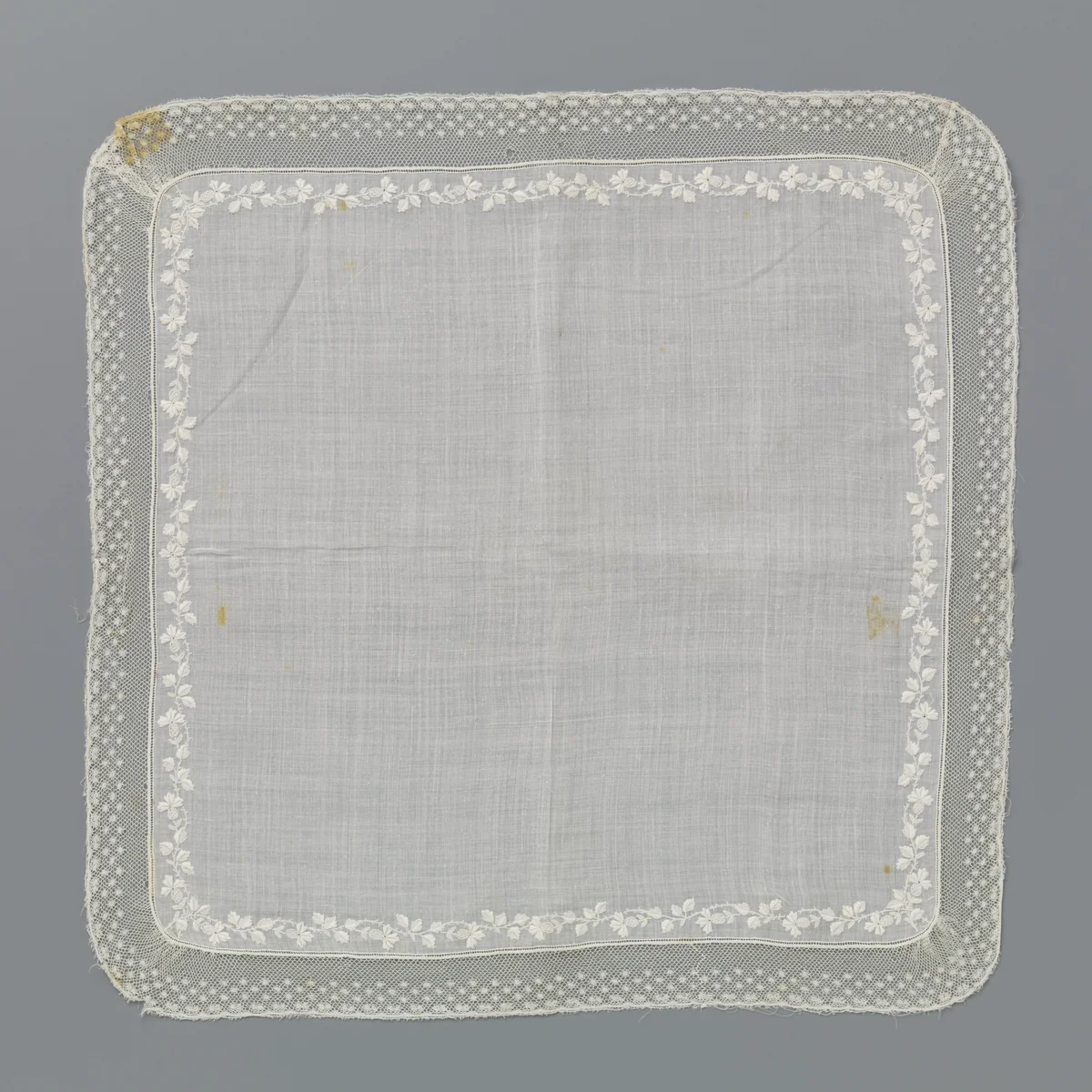 Zakdoek van batist met dunne golvende tak van plumetis borduurwerk en een rand kloskant met drie rijen moesjes by anonymous, textile, 1800-1899