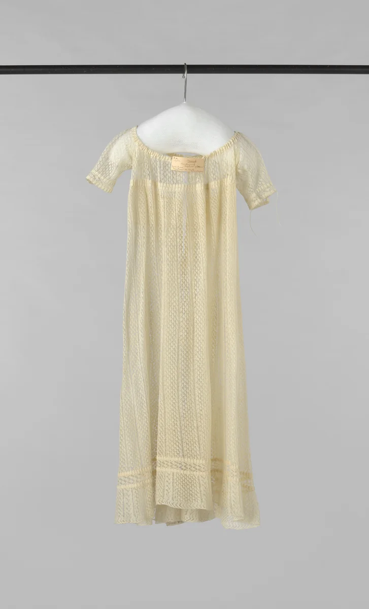Kinderjurk met korte mouw, hoge taille en achtersluiting met dun strikkoord, uitgevoerd in crème ajour breiwerk. by anonymous, other, 1830