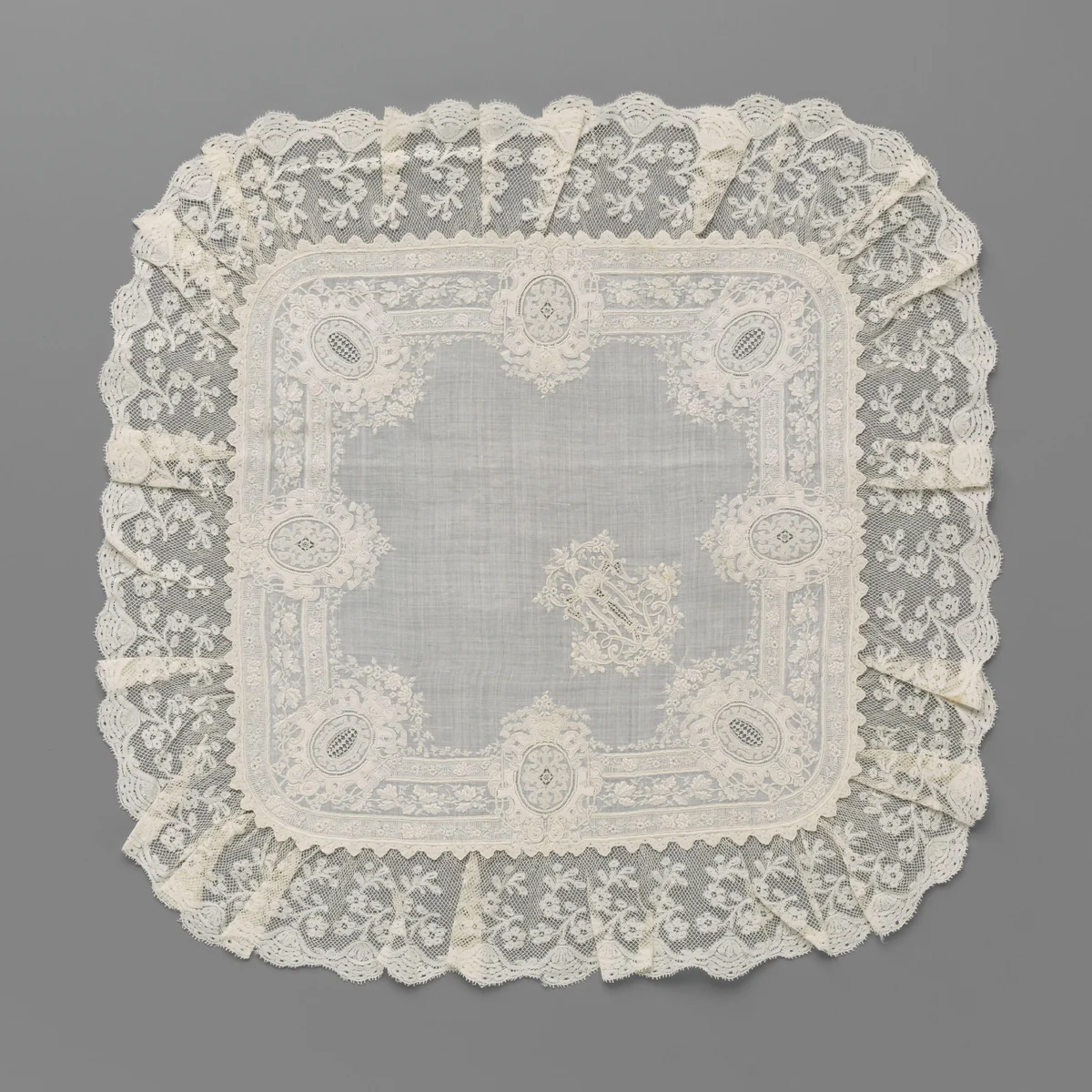 Zakdoek van batist waarop borduurwerk met acht rijk versierde medaillons langs de randen en een rijk versierde letter T by anonymous, textile, 1890-1895