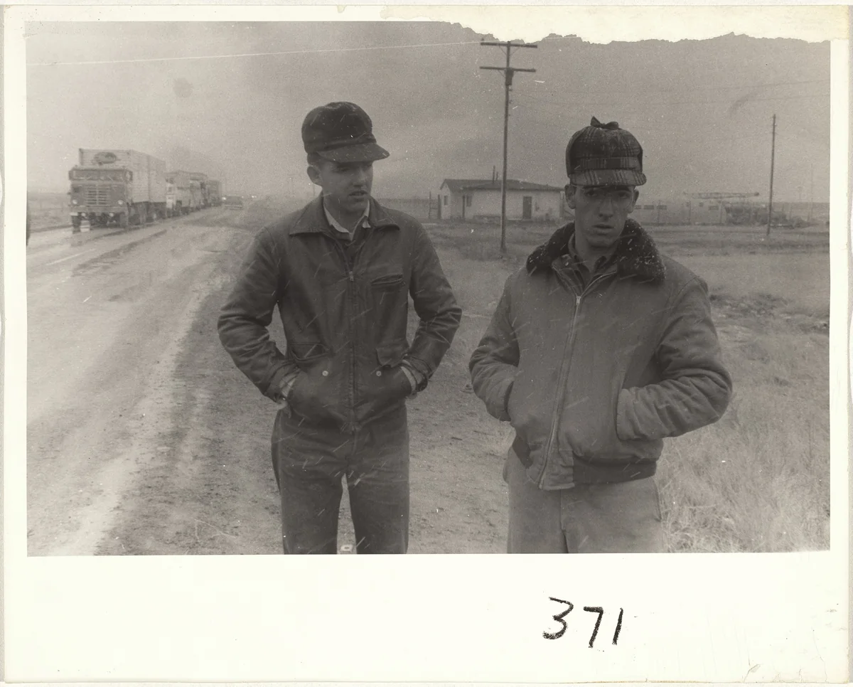 Two men standing by side of road in snow--U.S. 66 between Winslow and Flagstaff, Arizona by Robert Frank, photograph, 1955