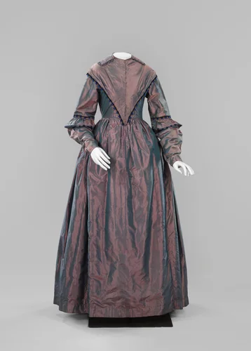 Japon met platliggende kraag, lange mouwen en een puntvormig voorlijf van paarsgroene changeantzijde, gevoerd met geglansd paars katoen; passementen in blauw, zwart en beige by anonymous, other, 1840-1850