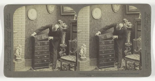 "Building up" an Underwood Patent Extension Stereograph Cabinet, - in a home Library. by Underwood & Underwood, photograph, 1901