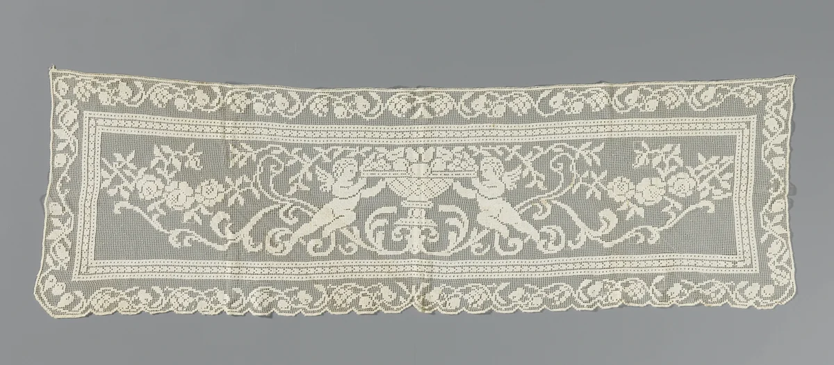 Doek van kantborduurwerk met een schaal met vrucht gesteund door twee cupido's by anonymous, textile, 1900-1924
