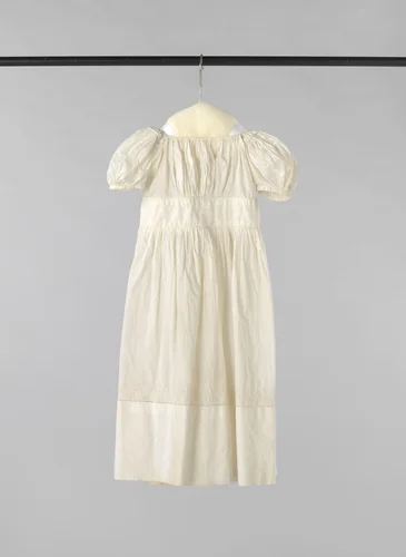 Kinderjurk van wit linnen met een korte pofmouw, een kort lijfje met fijne plooitjes, een brede gladde tailleband en en een fijngeplooide rok, versierd met Engels borduurwerk by anonymous, other, 1800-1835