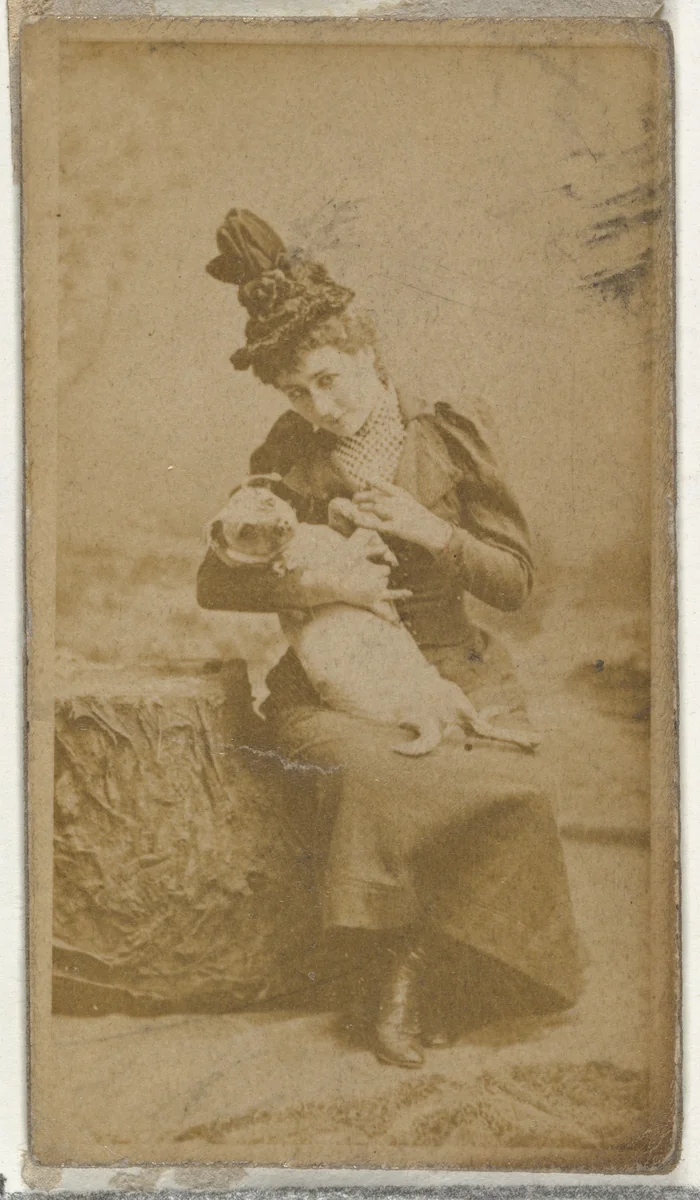 [Actress cradling small dog], from the Actors and Actresses series (N145-8) issued by Duke Sons & Co. to promote Duke Cigarettes by W. Duke, Sons & Co., photograph, 1890-1895
