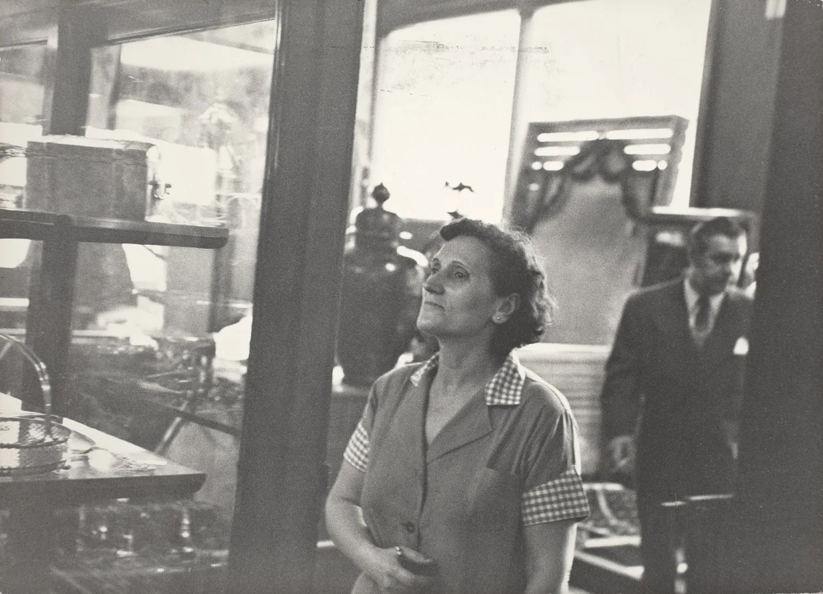At some time during the afternoon Lena might be seen looking at the silverware at Lawner's Auctioneers, next to Benny's. by Robert Frank, photograph, 1951