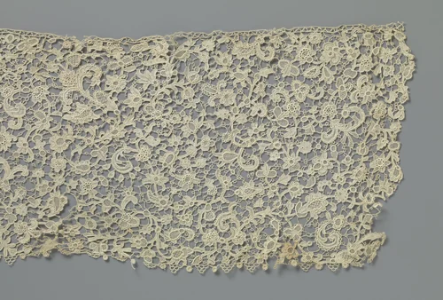 Strook naaldkant met schuin geplaatste rozetbloem tussen drie omkrullende bladeren en veelsoortige bloemen by anonymous, other, 1875-1899