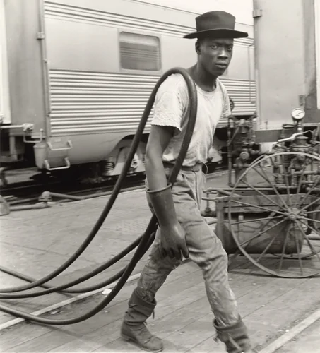 Railroad Passenger Car Maintenance Man. Air Hoses Were Used to Clean the Cars, Chicago, Illinois by Wayne Miller, photograph, 1947