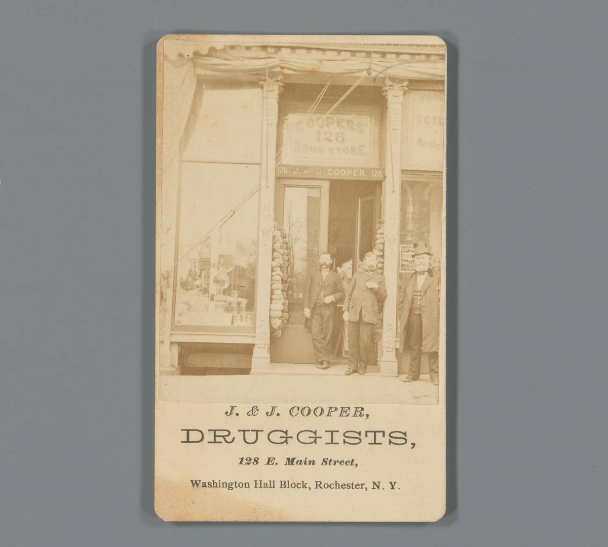Gezicht op de etalage van drogist J. & J. Cooper met personeel in Rochester, New York by anonymous, photograph, 1850-1915