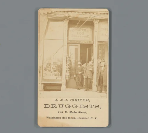 Gezicht op de etalage van drogist J. & J. Cooper met personeel in Rochester, New York by anonymous, photograph, 1850-1915