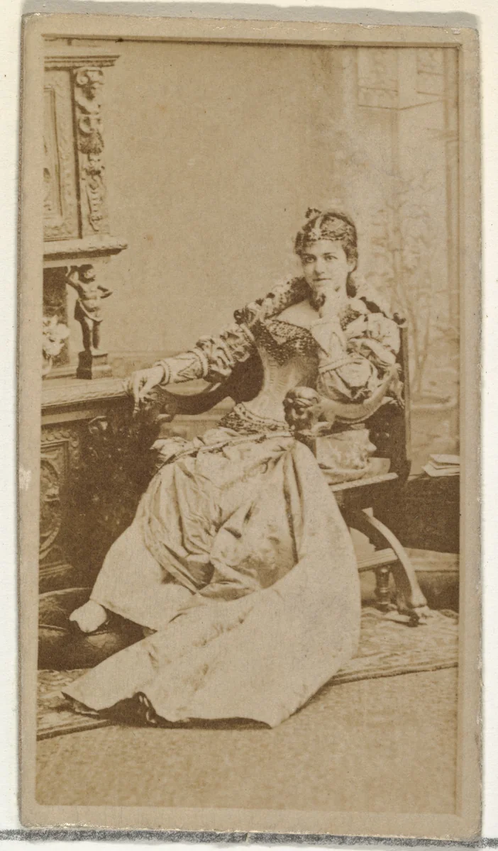 [Actress in studio reclining in heavy wooden chair], from the Actors and Actresses series (N145-8) issued by Duke Sons & Co. to promote Duke Cigarettes by W. Duke, Sons & Co., photograph, 1890-1895