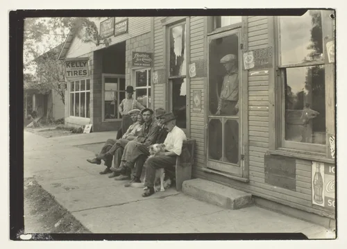 Men With Dog Sitting On Bench In Front Of General Store by Lewis Wickes Hine, photograph, 1905-1915
